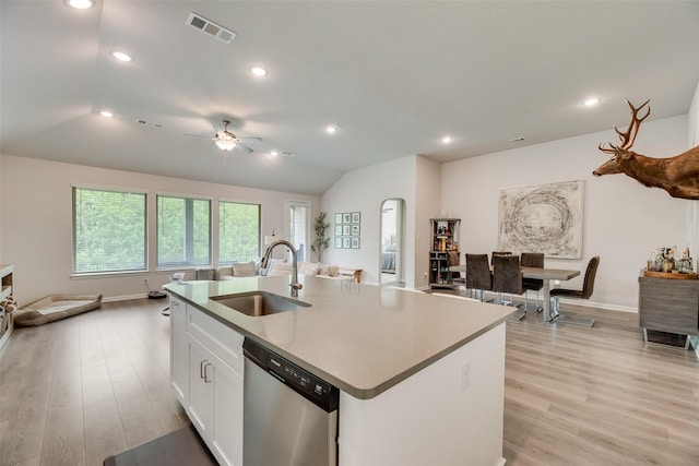kitchen with stainless steel dishwasher, a sink, an island with sink, light wood-type flooring, and visible vents