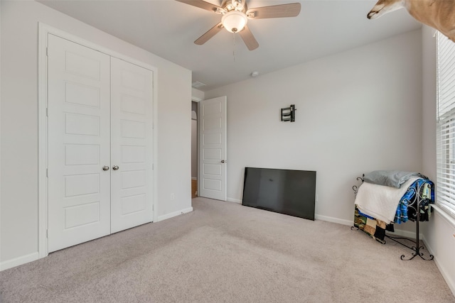 unfurnished bedroom with ceiling fan, carpet floors, a closet, and baseboards