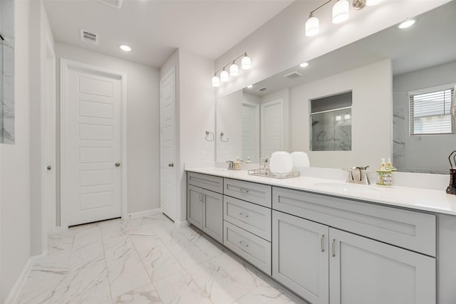 bathroom featuring double vanity, visible vents, a sink, baseboards, and walk in shower