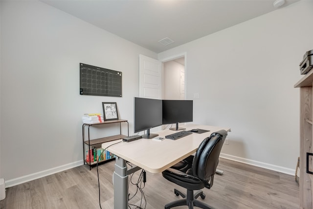 office featuring visible vents, light wood finished floors, and baseboards