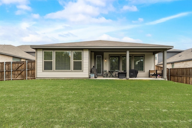 rear view of property featuring a patio area, a lawn, and a fenced backyard