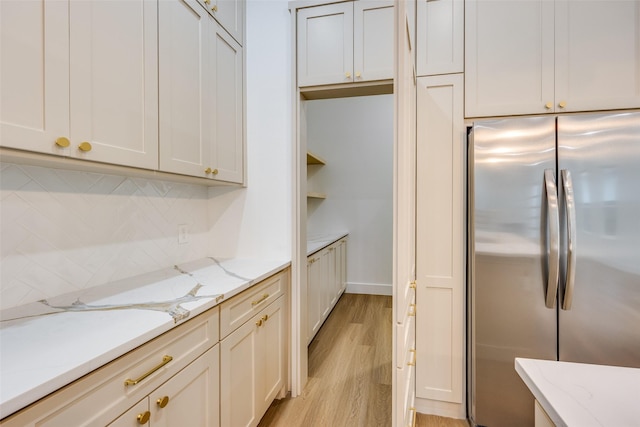 618 N Cliff, Dallas, TX 75203 - kitchen with stainless steel fridge, light wood-type flooring, tasteful backsplash, and light stone countertops