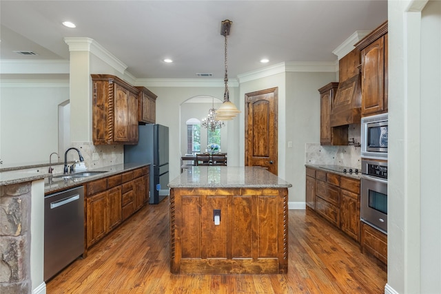 living room with a tray ceiling, wood finished floors, visible vents, and ornamental molding