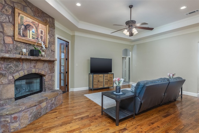 kitchen featuring stainless steel dishwasher, a sink, arched walkways, and light wood-style flooring