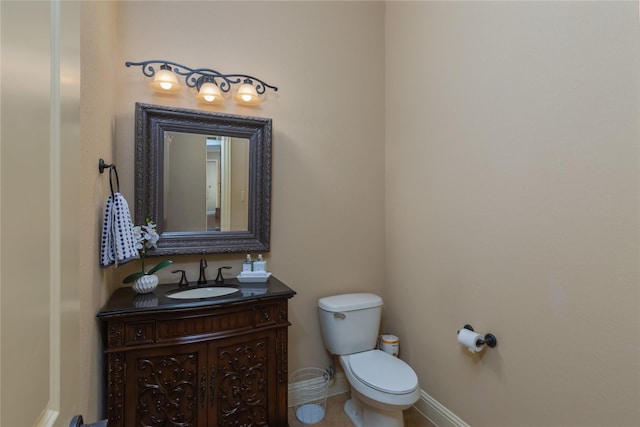 bathroom featuring toilet, vanity, tile patterned floors, and baseboards