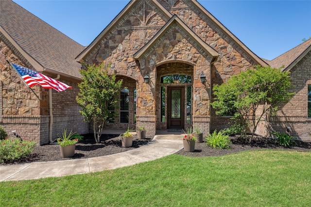 view of property hidden behind natural elements with fence, a front lawn, brick siding, and concrete driveway