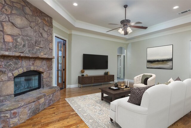 100 Meadow Arbor Dr, Weatherford, TX 76085 - living area featuring crown molding, wood finished floors, a stone fireplace, a raised ceiling, and ceiling fan