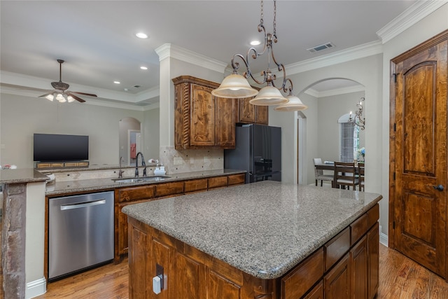 living area with a stone fireplace, visible vents, arched walkways, and a tray ceiling