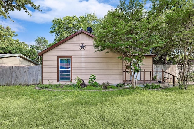 view of side of property with fence and a yard