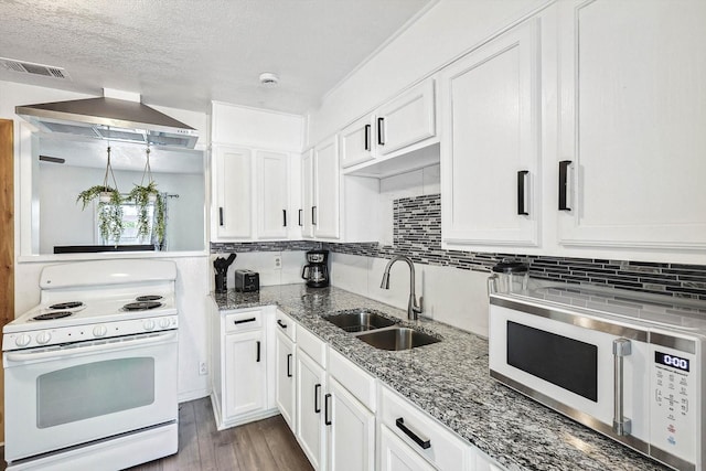 kitchen featuring backsplash, white cabinetry, a sink, and white appliances