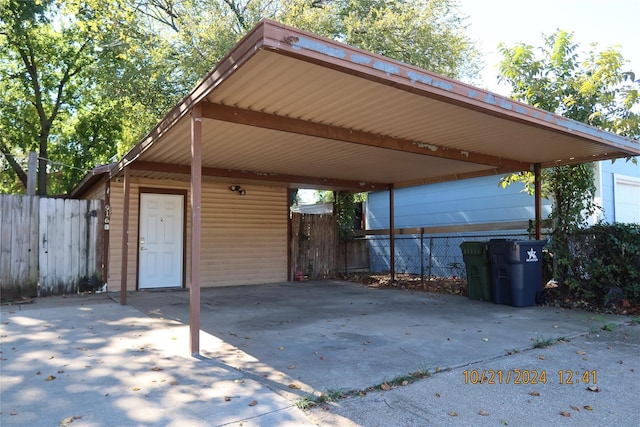 view of patio / terrace featuring a carport, fence, and concrete driveway