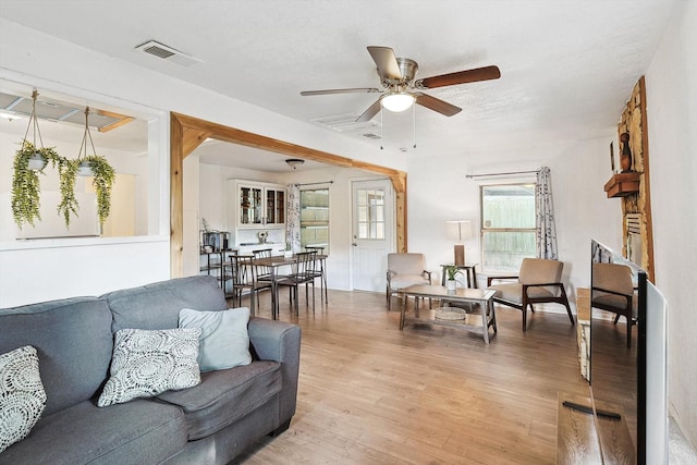 living area featuring a ceiling fan, light wood-style floors, and visible vents