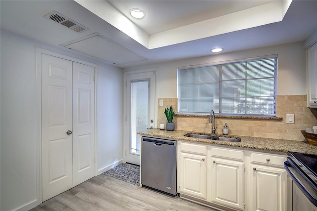 kitchen with stainless steel dishwasher, tasteful backsplash, a sink, light wood-type flooring, and electric range