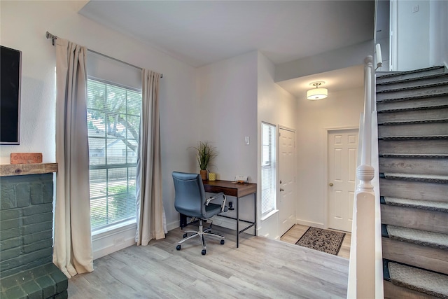 entrance foyer with stairway, a healthy amount of sunlight, and light wood-style flooring