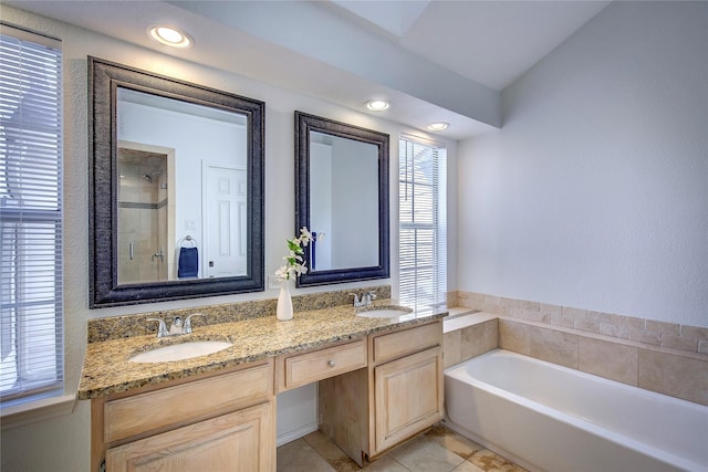 bathroom featuring a garden tub, a sink, double vanity, and a stall shower
