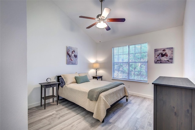bedroom with vaulted ceiling, a ceiling fan, wood finished floors, and baseboards