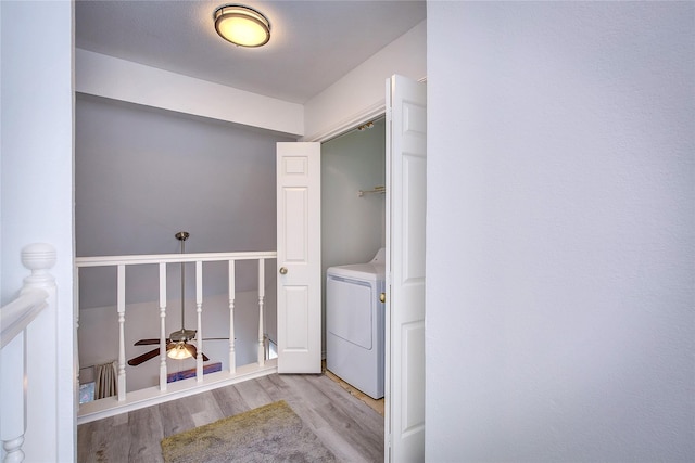 clothes washing area with wood finished floors, laundry area, ceiling fan, and washer / clothes dryer