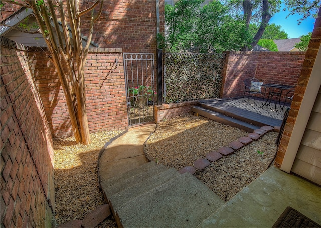 view of yard with a gate, a wooden deck, and fence
