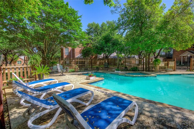 pool featuring fence, a patio area, and a community hot tub