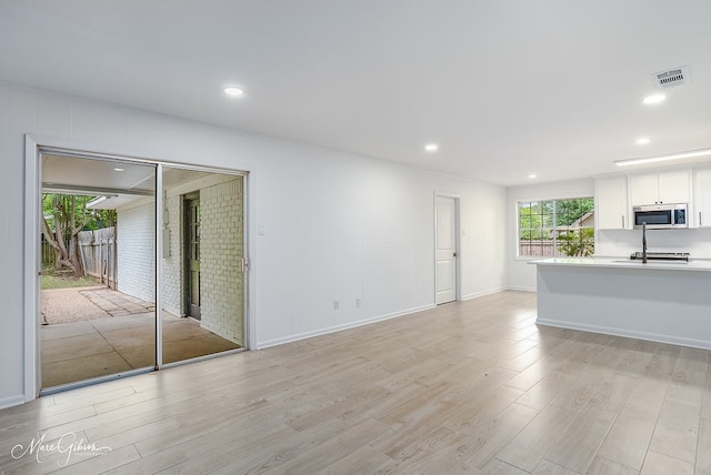 unfurnished living room featuring baseboards, recessed lighting, visible vents, and light wood-type flooring