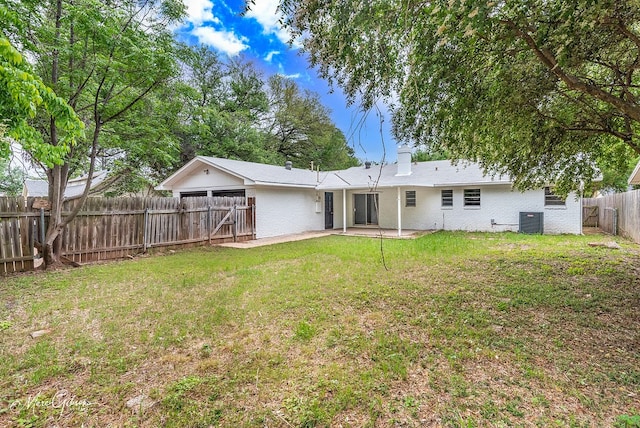 back of house featuring a patio area, a fenced backyard, a yard, cooling unit, and brick siding