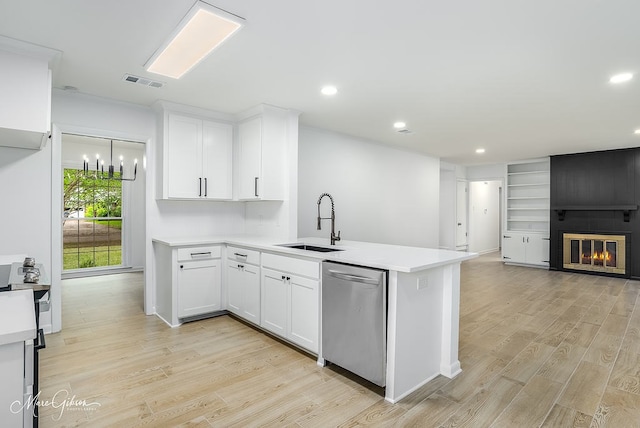 kitchen featuring light wood finished floors, a sink, visible vents, dishwasher, and light countertops