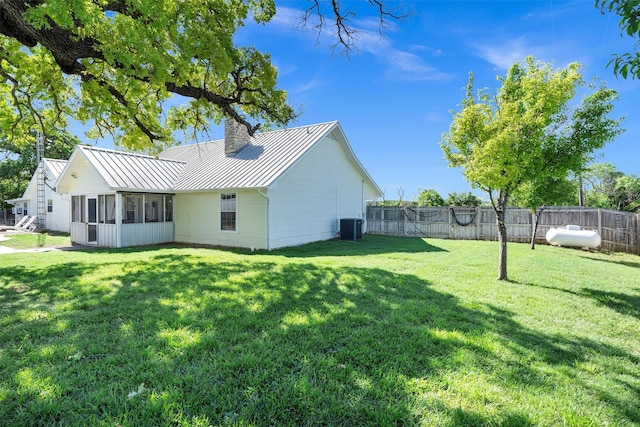 13122 Lipan Hwy, Lipan, TX 76462 - view of home's exterior with a chimney, central AC unit, a standing seam roof, a lawn, and a sunroom