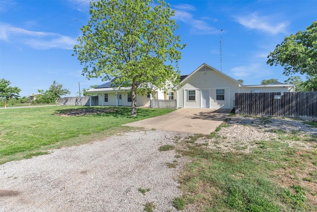13122 Lipan Hwy, Lipan, TX 76462 - view of front facade with a front lawn, fence, roof mounted solar panels, and dirt driveway