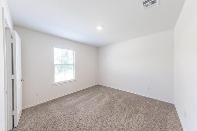 carpeted spare room with baseboards and visible vents