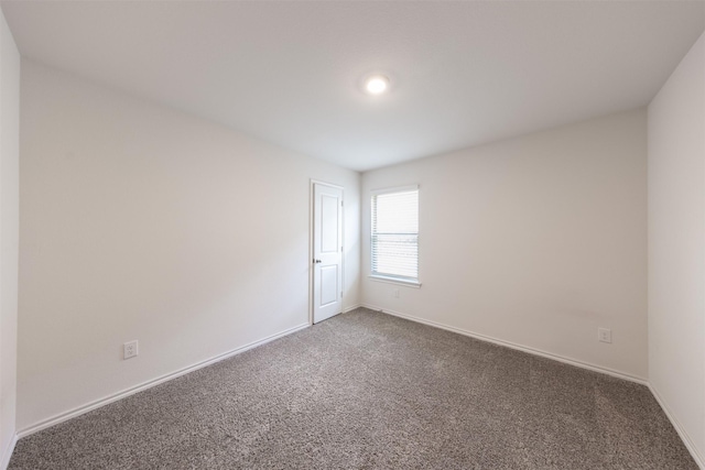 empty room featuring baseboards and carpet flooring