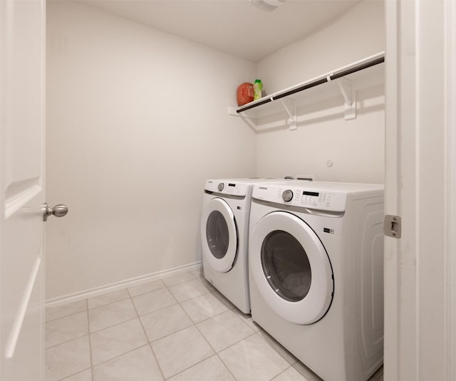 washroom with washer and dryer, baseboards, laundry area, and light tile patterned floors