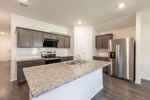 kitchen with dark brown cabinetry, appliances with stainless steel finishes, tasteful backsplash, and a sink