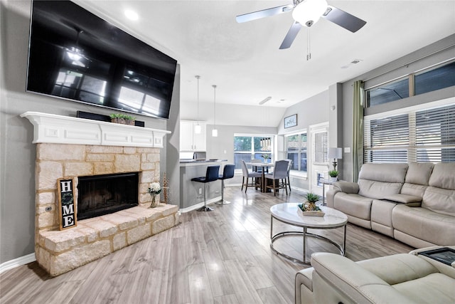 living area with wood finished floors, baseboards, a fireplace, and ceiling fan