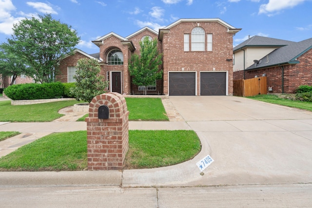 traditional home with driveway, fence, brick siding, a garage, and a front yard
