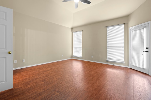unfurnished room with vaulted ceiling, wood finished floors, a ceiling fan, and baseboards