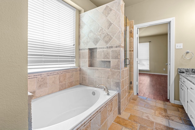 full bathroom with a shower stall, a garden tub, and vanity