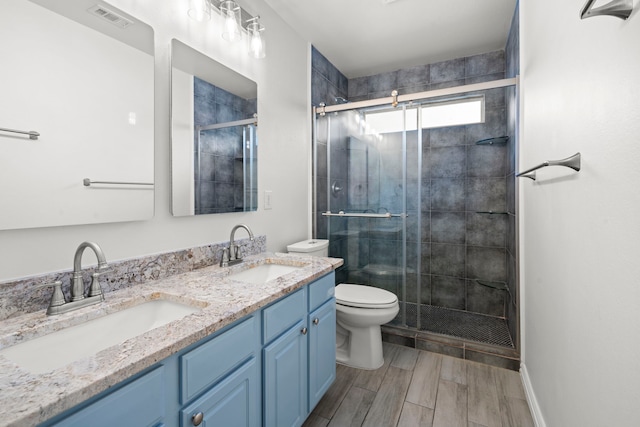 bathroom with visible vents, a stall shower, and a sink