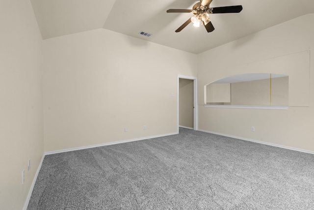 spare room with baseboards, visible vents, lofted ceiling, ceiling fan, and carpet floors