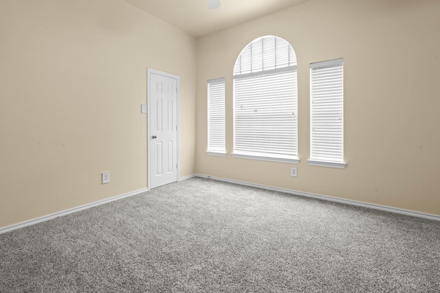 spare room with baseboards, carpet flooring, and ceiling fan