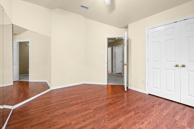 unfurnished bedroom featuring wood finished floors, visible vents, a ceiling fan, a closet, and baseboards