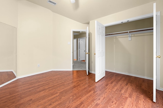 unfurnished bedroom featuring baseboards, wood finished floors, visible vents, and a closet