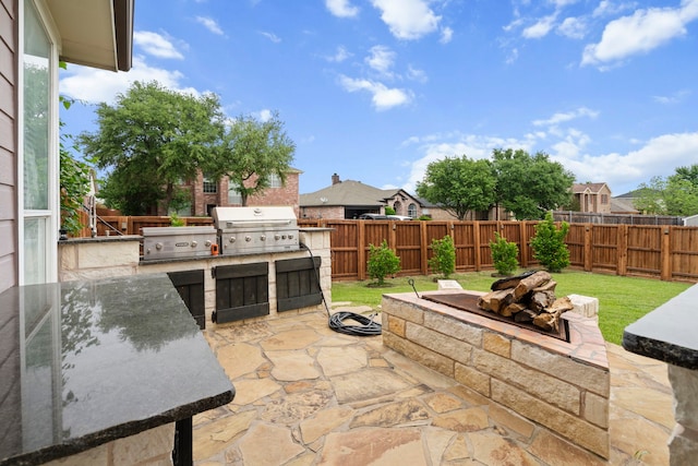 view of patio with an outdoor kitchen, grilling area, and a fenced backyard