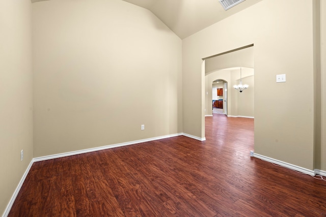 empty room with vaulted ceiling, visible vents, arched walkways, dark wood-type flooring, and a notable chandelier