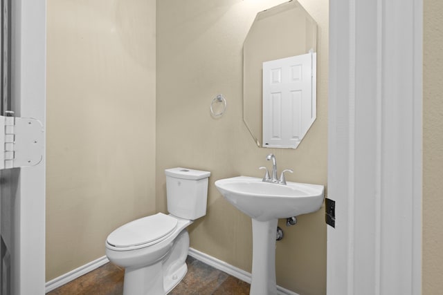 bathroom featuring baseboards and toilet