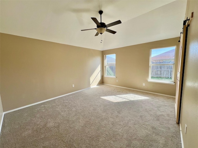 525 Reagan Ln, Burleson, TX 76028 - carpeted spare room with a barn door, a healthy amount of sunlight, baseboards, and ceiling fan