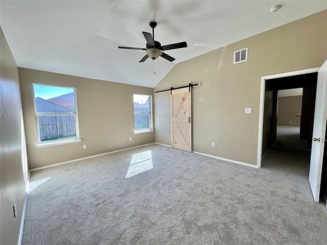 525 Reagan Ln, Burleson, TX 76028 - unfurnished bedroom with a barn door, vaulted ceiling, carpet floors, baseboards, and visible vents