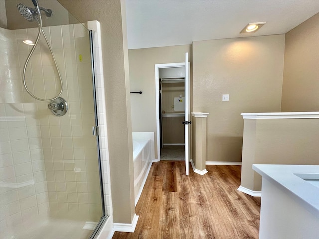 525 Reagan Ln, Burleson, TX 76028 - bathroom with baseboards, wood finished floors, a shower stall, a garden tub, and vanity