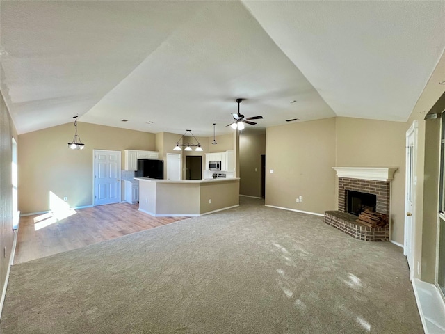 525 Reagan Ln, Burleson, TX 76028 - unfurnished living room featuring light colored carpet, ceiling fan, vaulted ceiling, and a fireplace