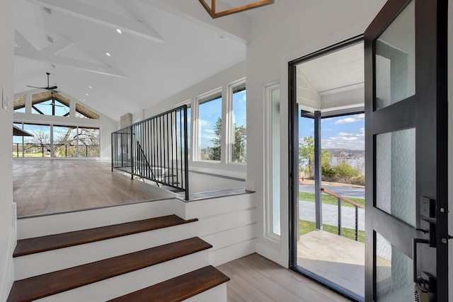 interior space with ceiling fan, lofted ceiling, and wood finished floors