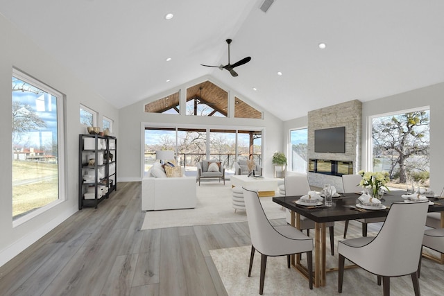 dining area with a wealth of natural light, vaulted ceiling with beams, and light wood-style flooring
